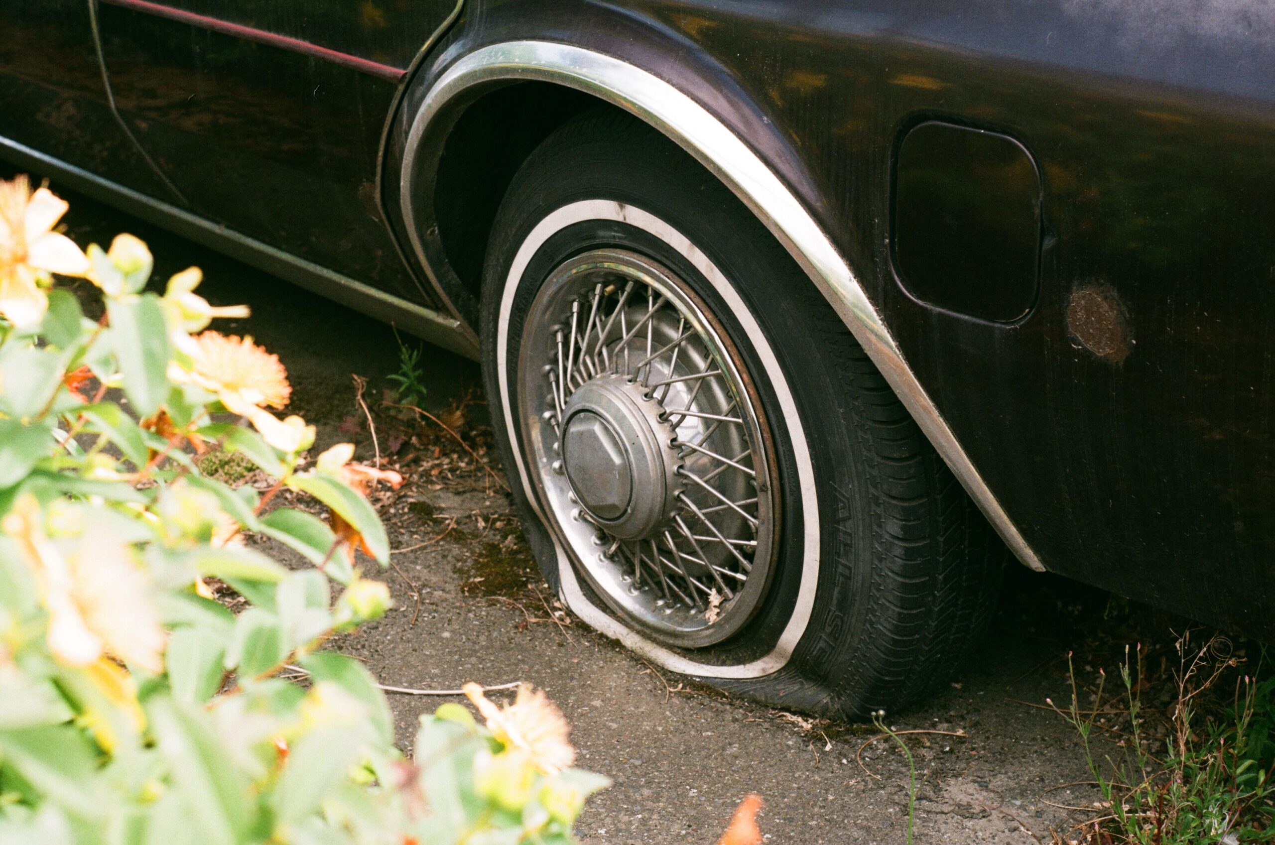 A black car with a flat tyre