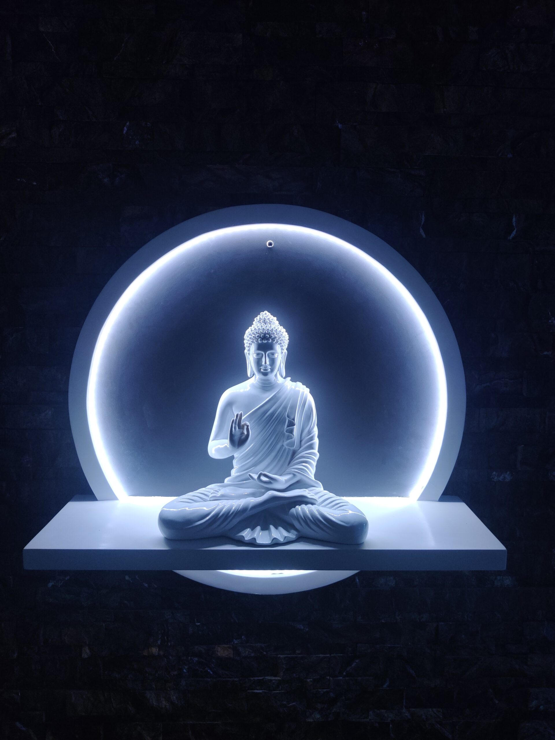 Seated Buddha is meditative pose in blue neon glow