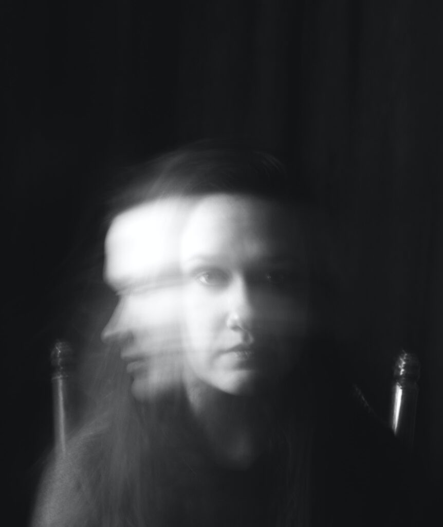 Black and white portrait of a woman in time-lapsed shot shaking head