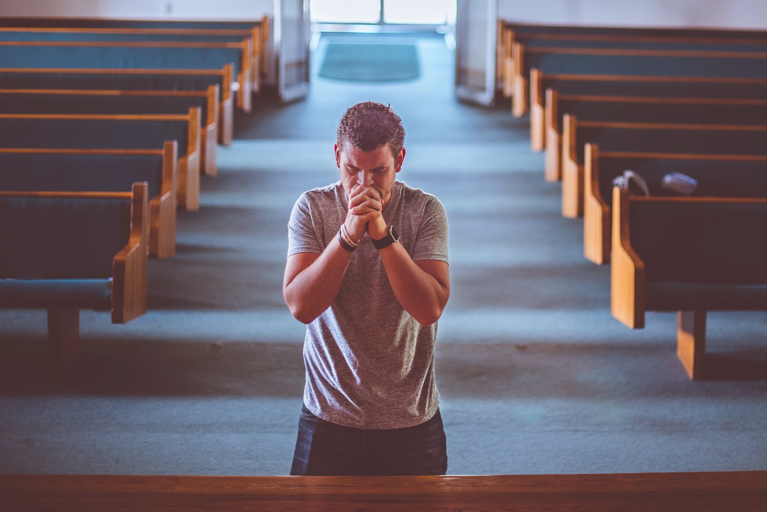 Man kneeling before alter in church
