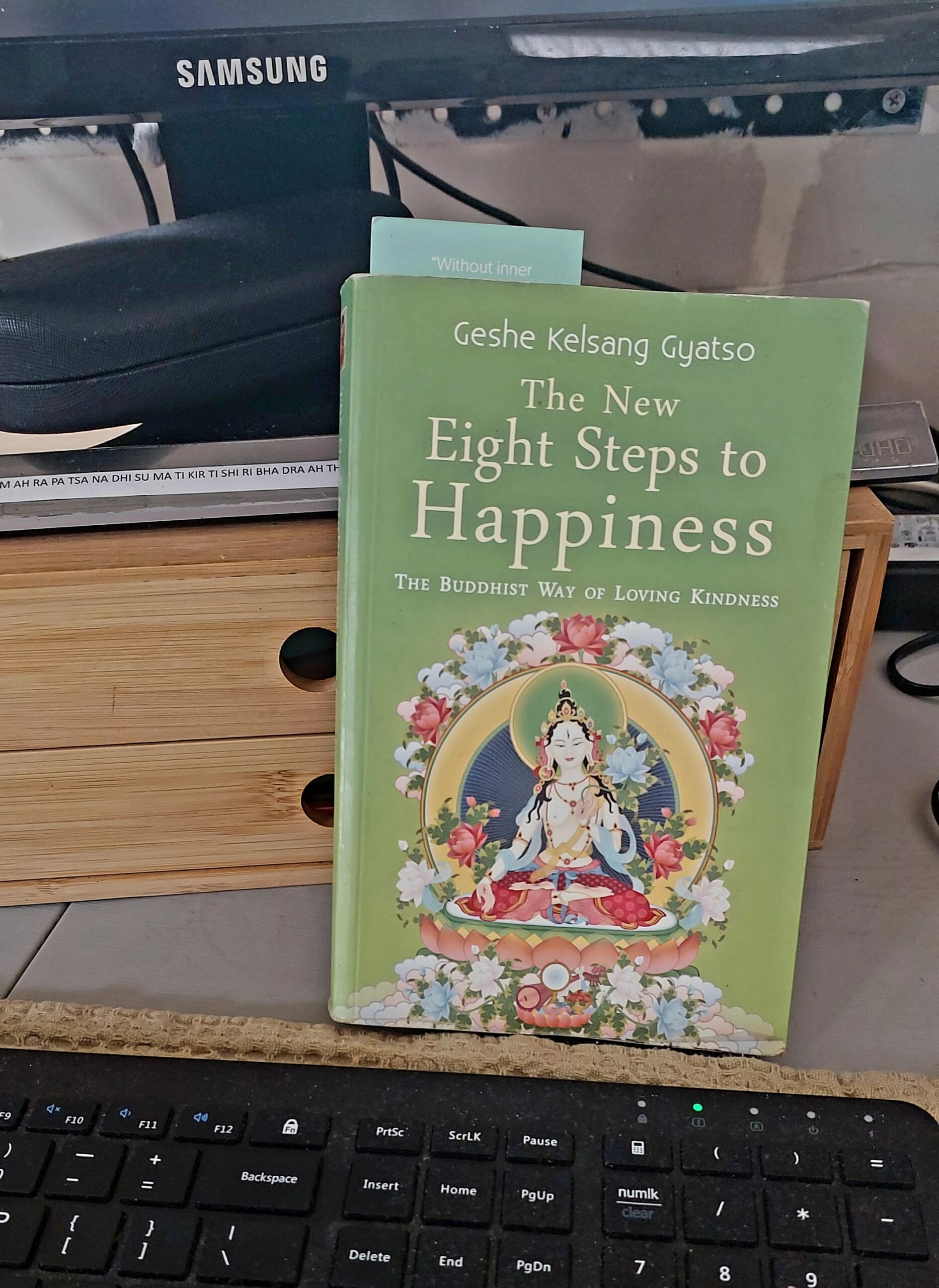 Book, Eight Steps to Happiness sitting on a desk