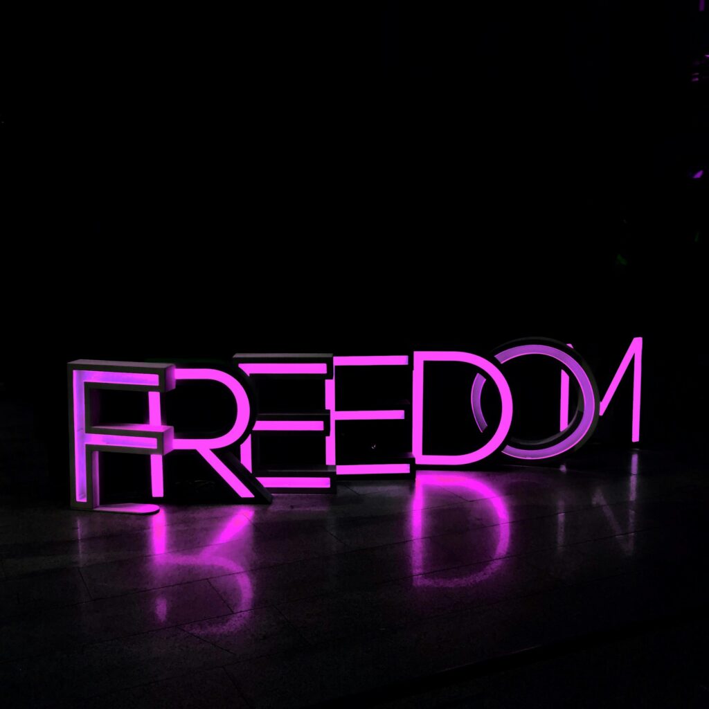 The word FREEDOM in purple neon on a black background