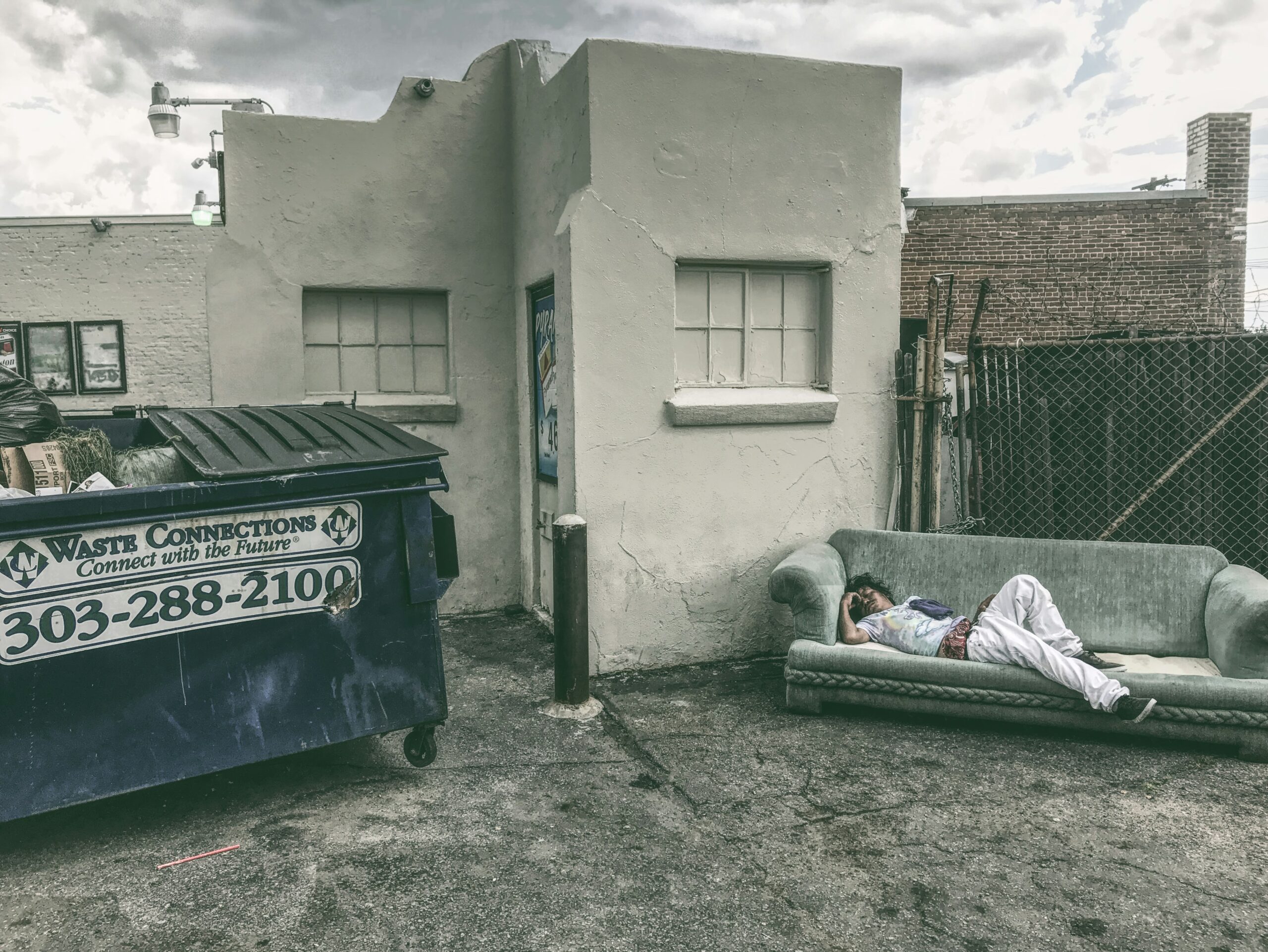 Stark image of a drunk sleeping on a couch on a rooftop