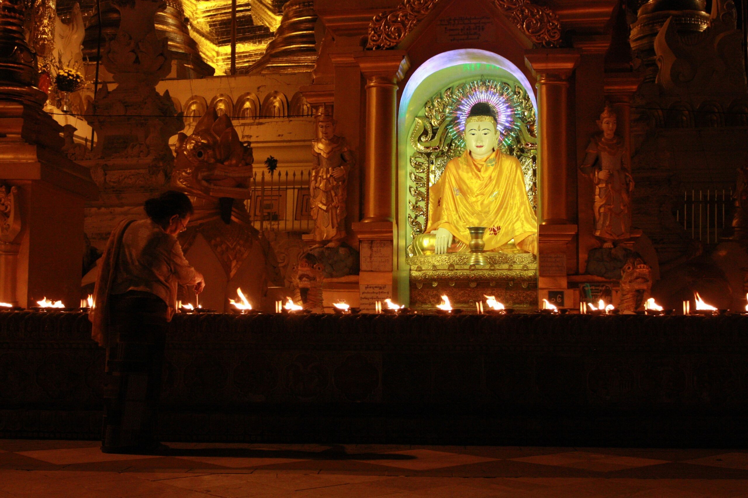 A woman lighting candles in a Buddhist gompa