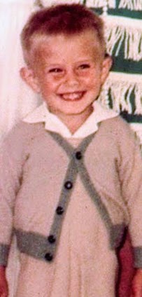 Smiling photo of a boy in a cardigan from the 1960's